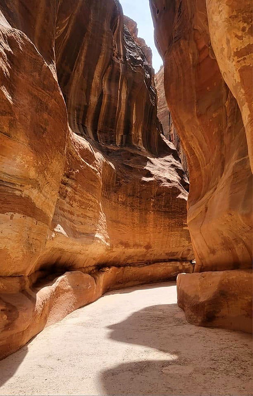 Paredes curvas de arenito rosado no Siq de Petra