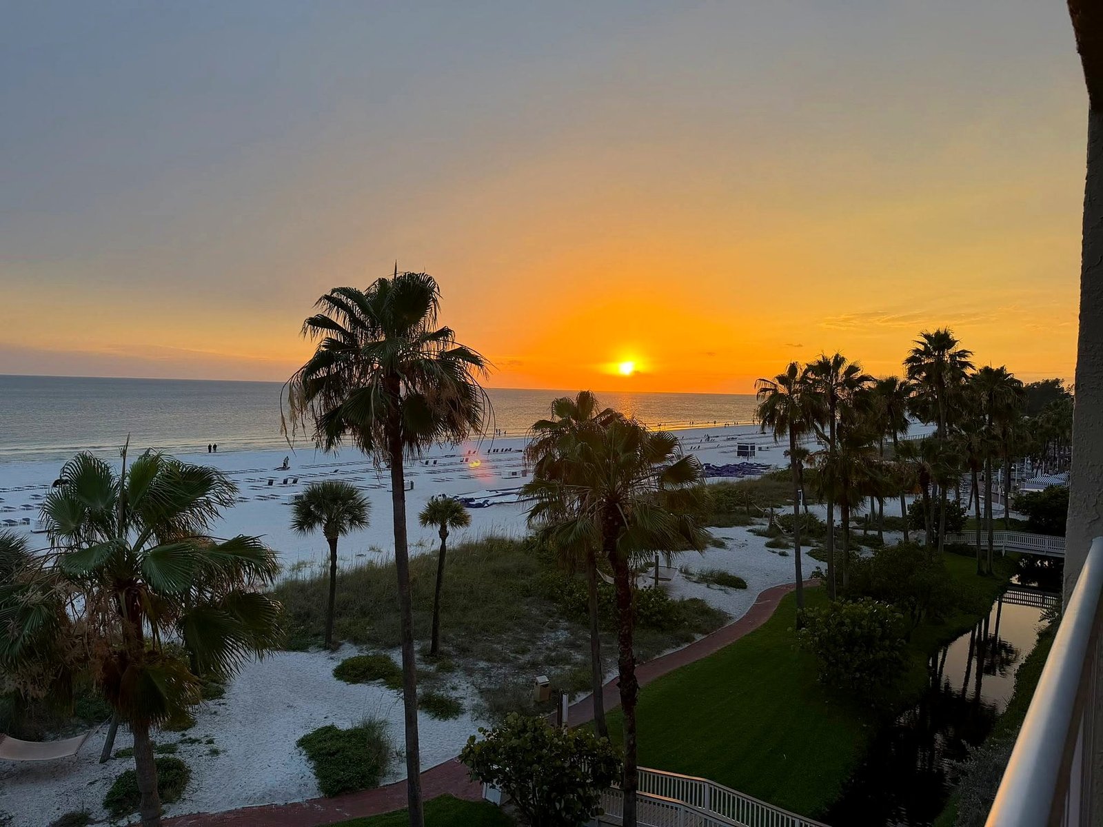 Pôr do sol sobre a areia branca e os coqueiros de St. Pete Beach, vista do alto de um hotel