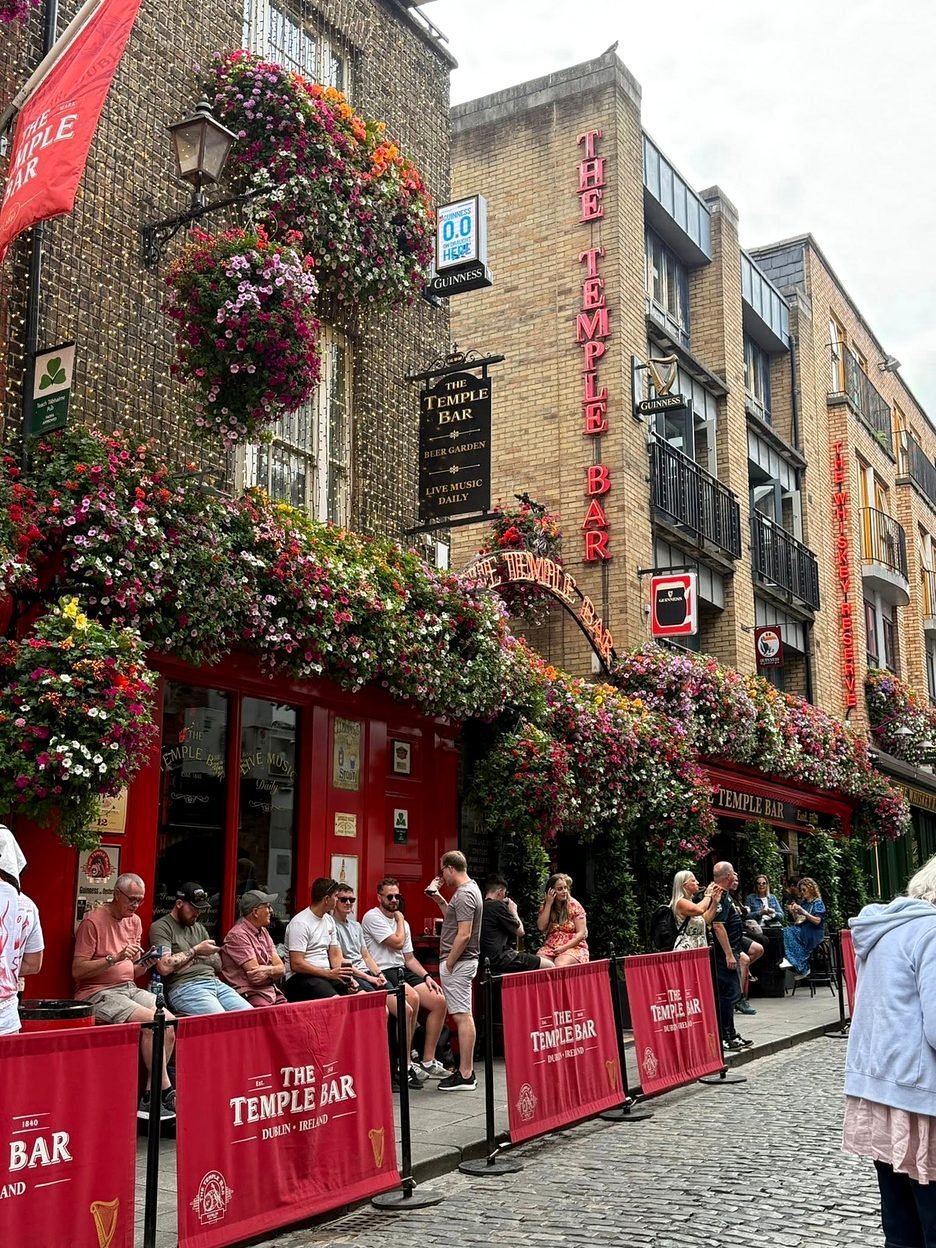 Pessoas na calçada do pub The Temple Bar em Dublin