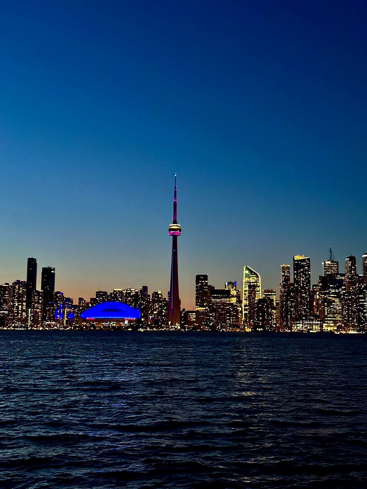 Skyline de Toronto iluminado à noite com a CN Tower e o Lago Ontário
