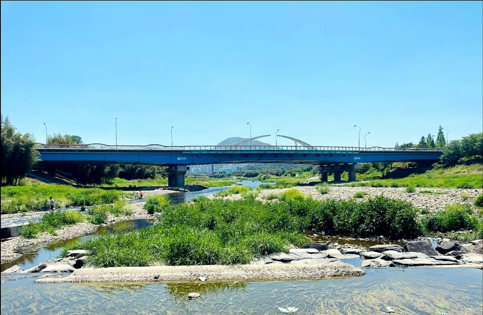 Rio Taehwa e ponte no centro de Ulsan em dia de céu azul