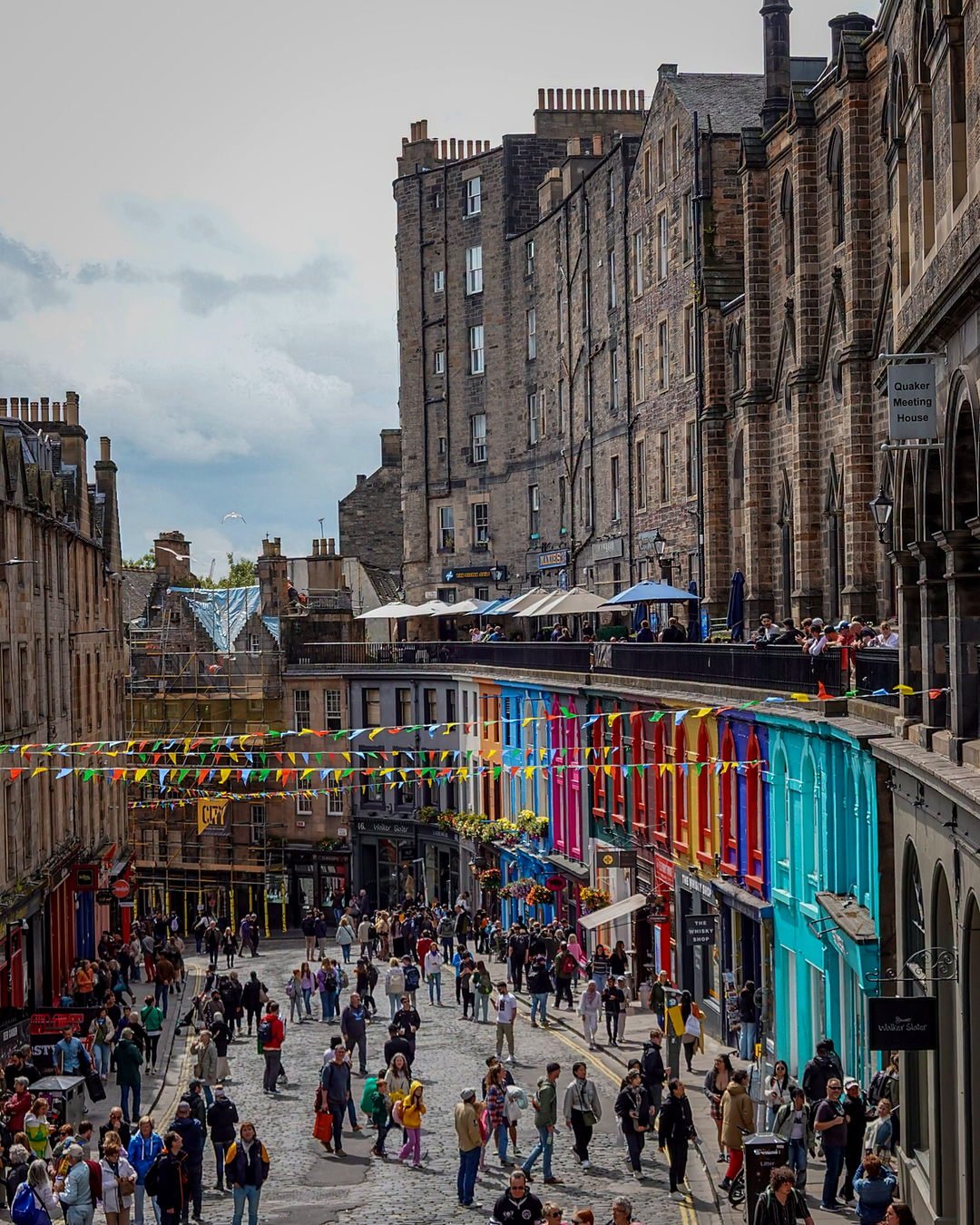 Victoria Street em Edimburgo com fachadas coloridas e bandeirinhas