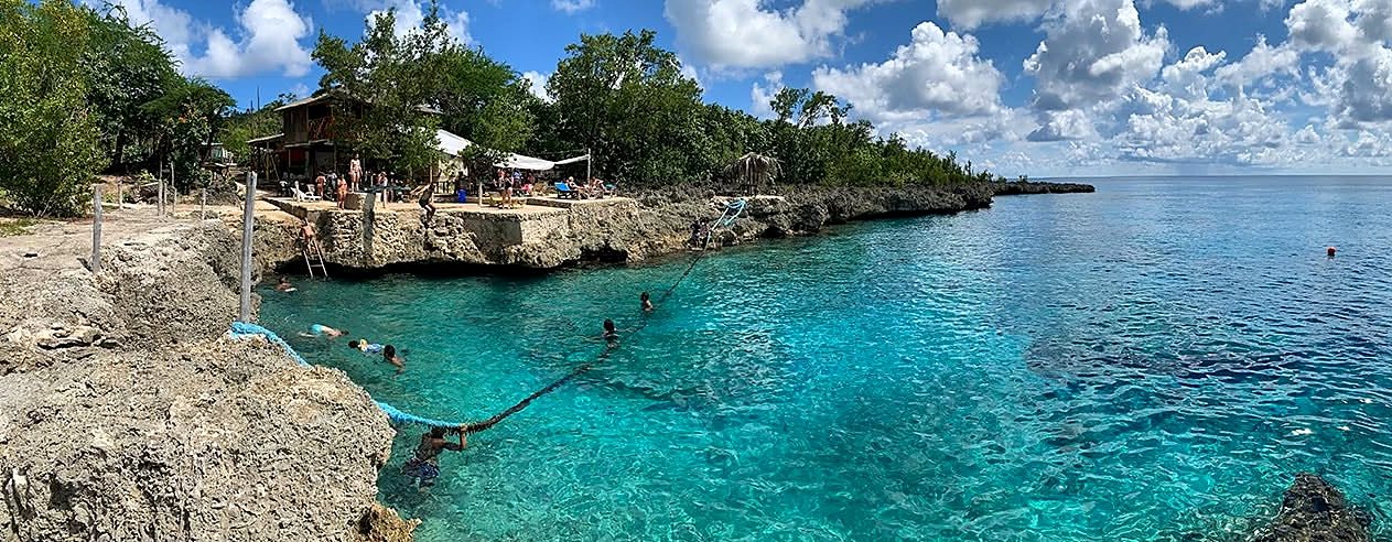 Piscina natural de West View em San Andrés, com água turquesa entre as rochas e banhistas