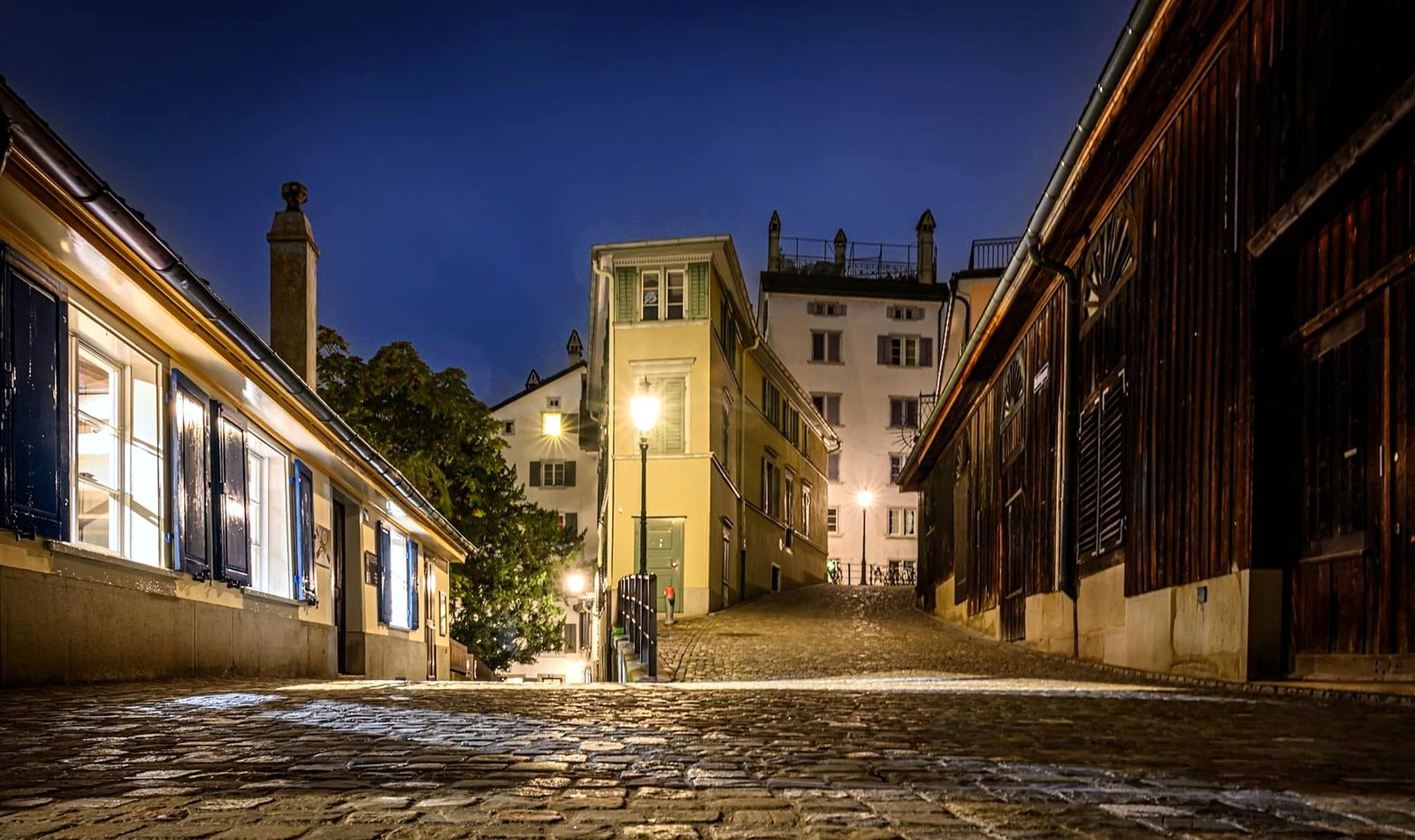 Ruela de pedra iluminada à noite no centro histórico de Zurique