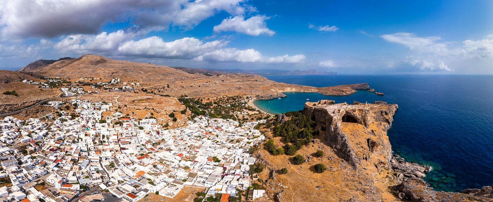 Vista aérea da Acrópole de Lindos no penhasco sobre o mar, com a vila e a baía ao fundo