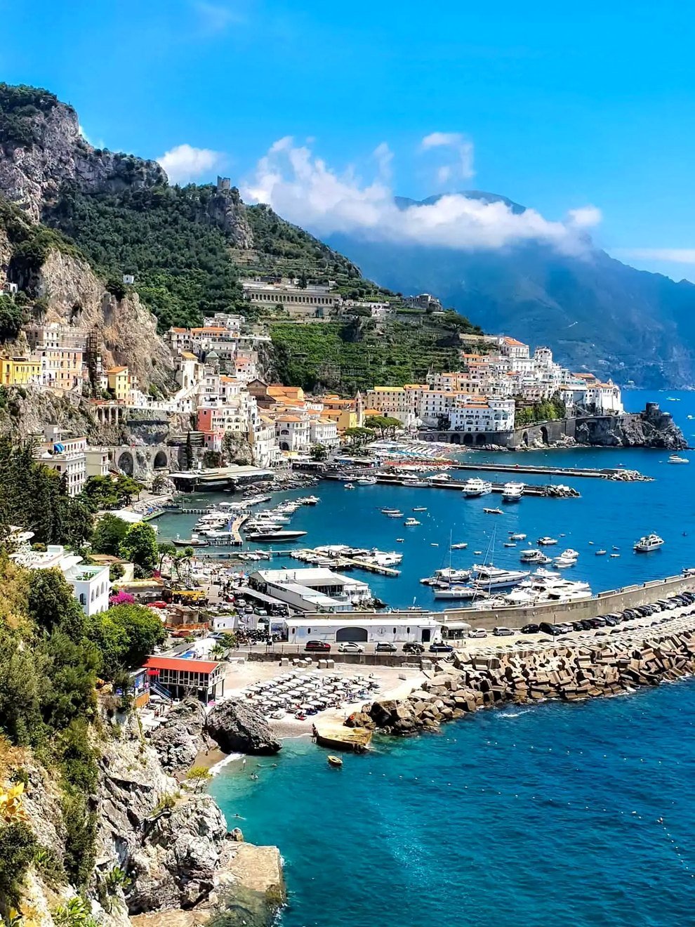 Vista panorâmica de Amalfi com o porto, barcos e a cidade na encosta