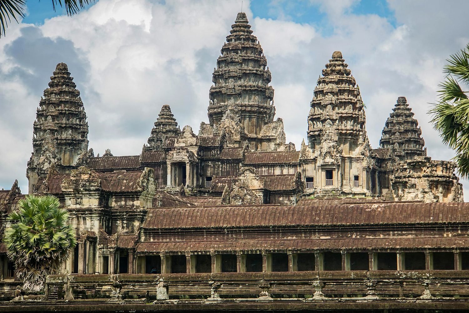 Torres de pedra de Angkor Wat entre palmeiras, em Siem Reap, Camboja