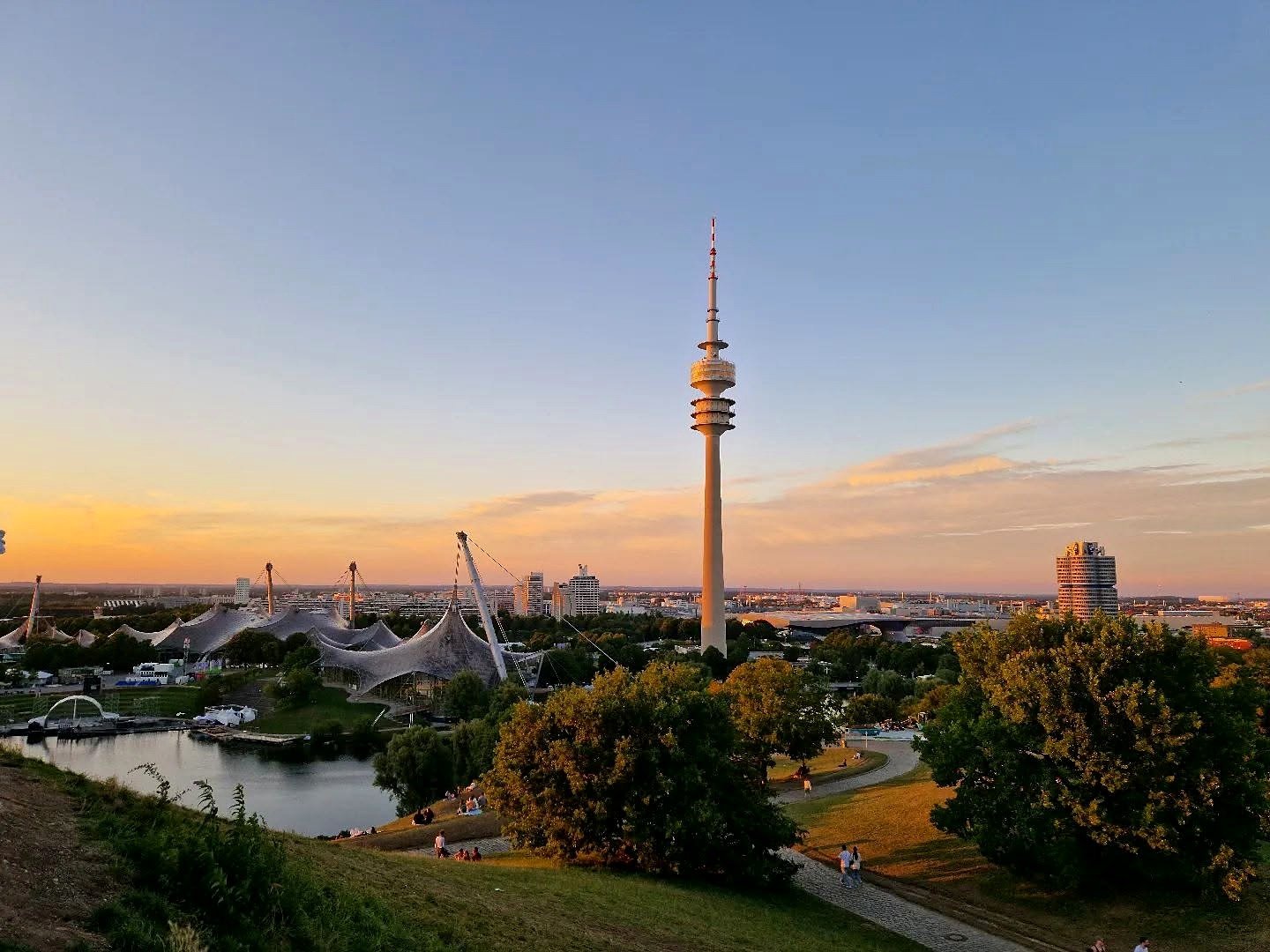 Guia brasileiro em Munique: vista do Olympiapark ao pôr do sol com a Torre Olímpica e a sede da BMW