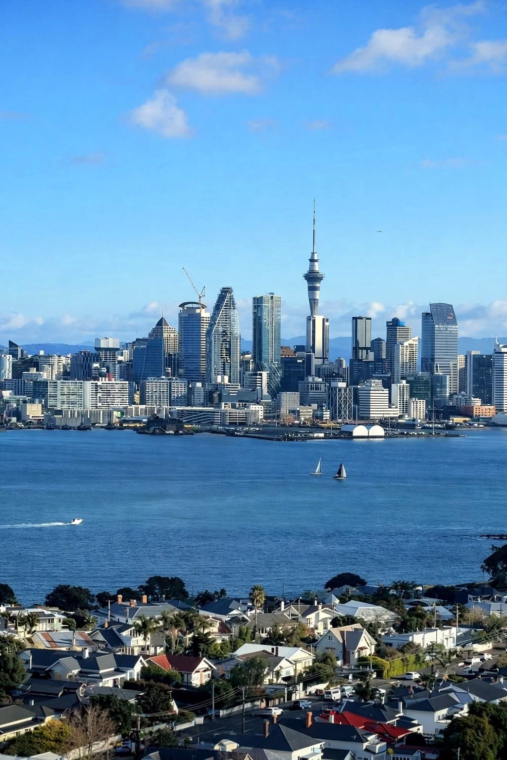 Vista do skyline de Auckland a partir de Devonport, com veleiros na baía