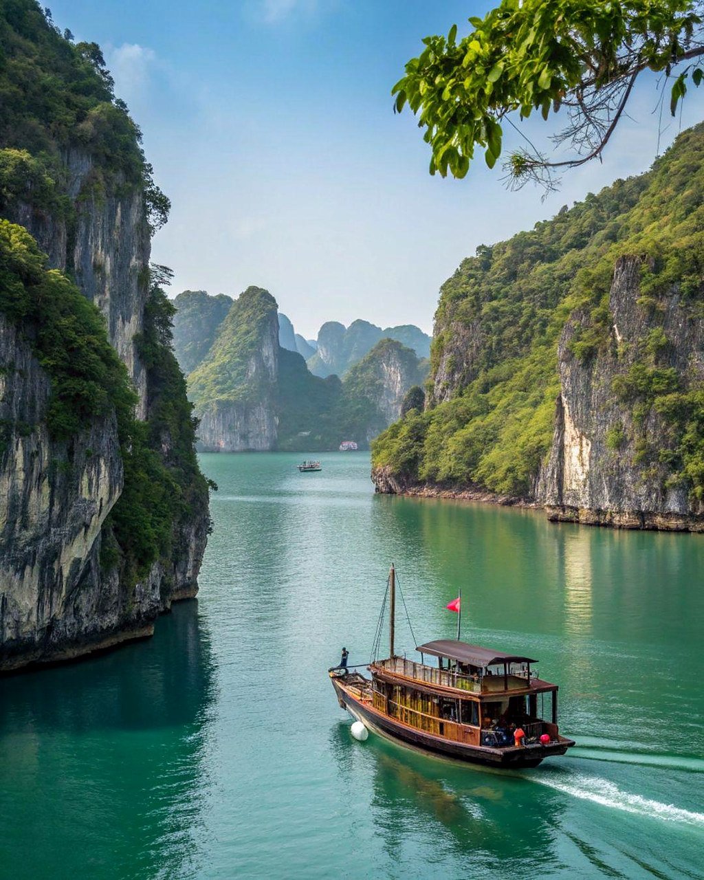 Barco tradicional navegando entre pared&otilde;es de calc&aacute;rio na Ba&iacute;a de Ha Long, no Vietn&atilde;