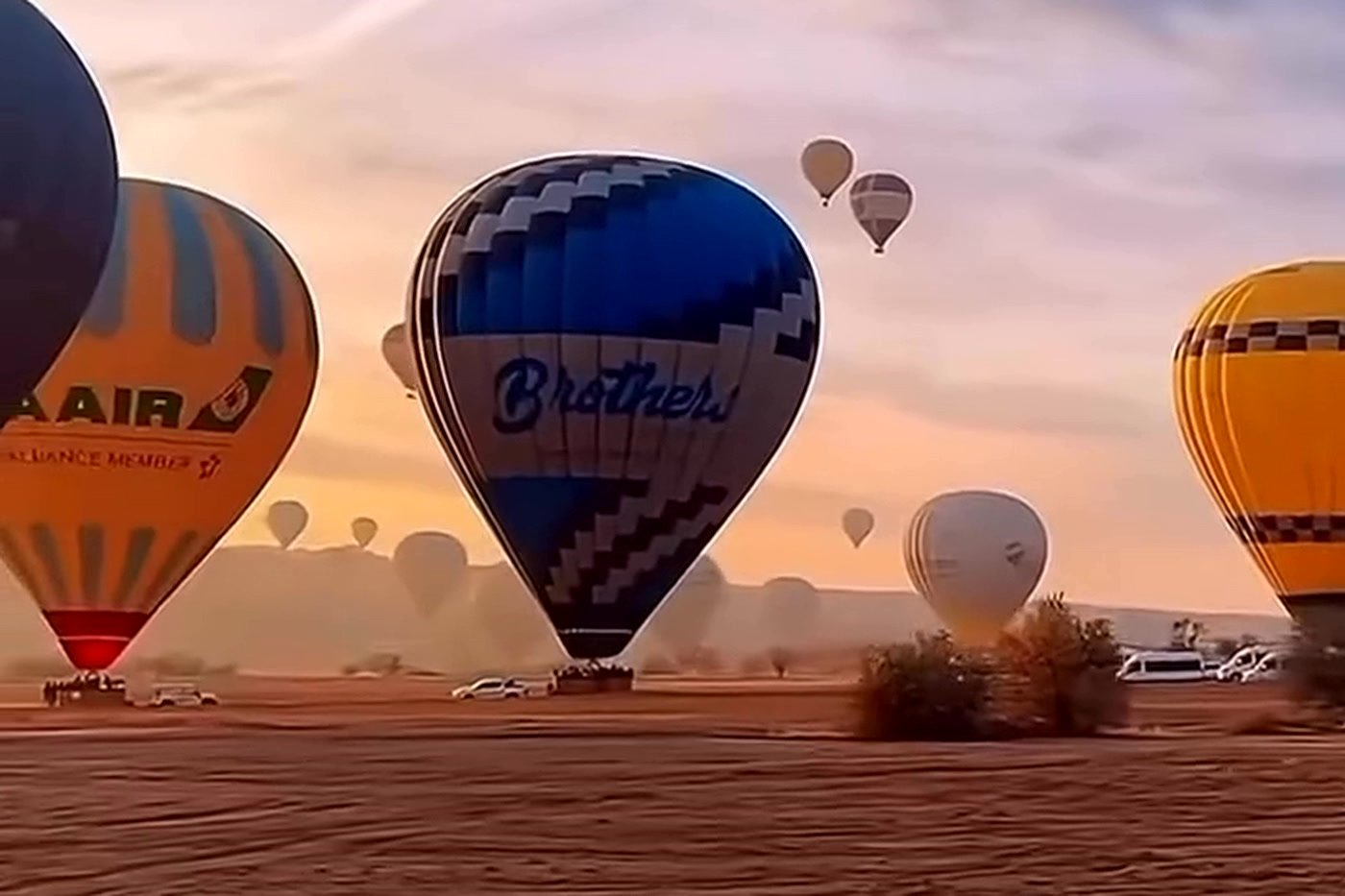 Balões ao amanhecer na Capadócia vistos de terra