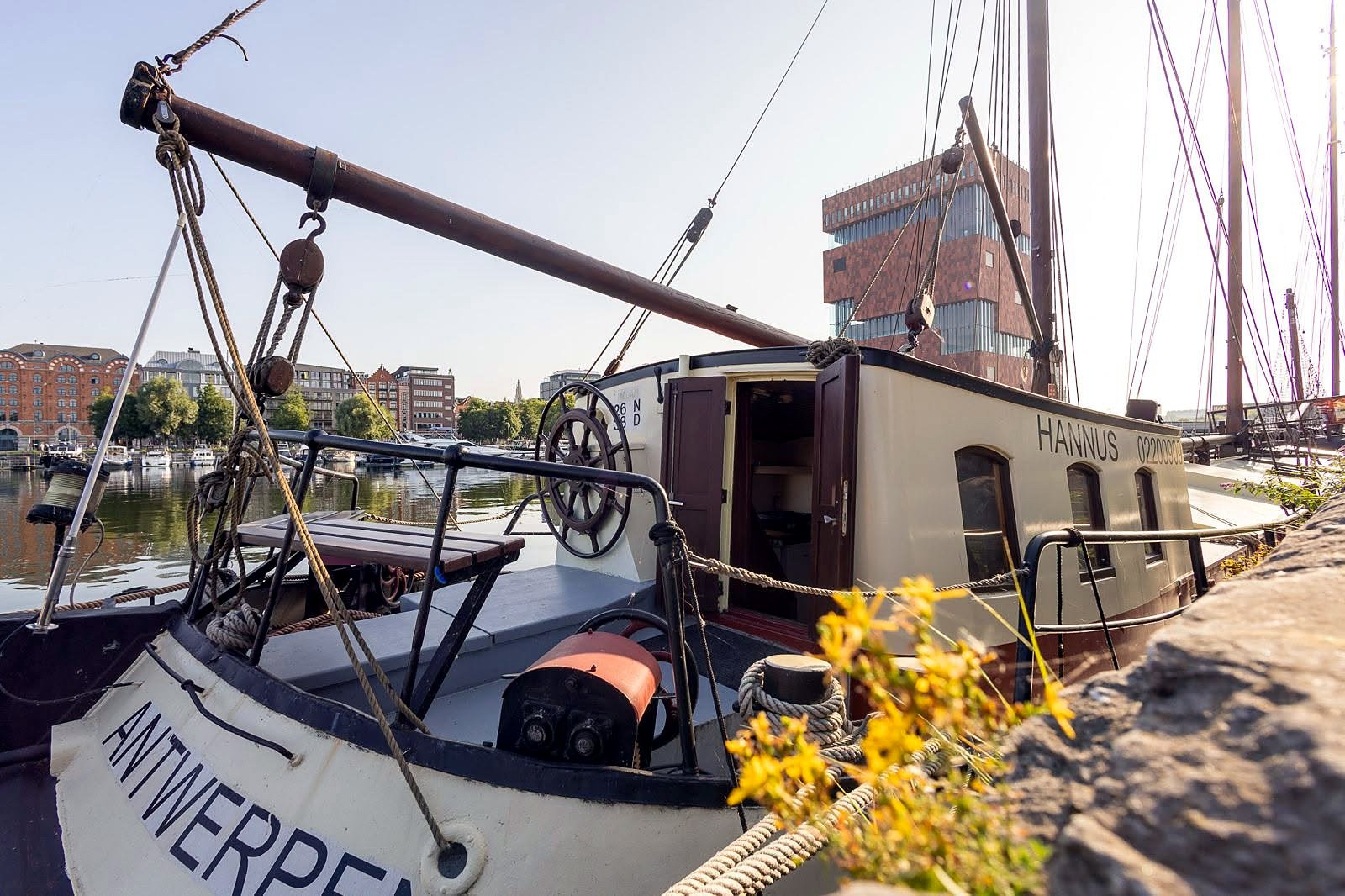 Barco histórico atracado no Eilandje com o Museu MAS ao fundo