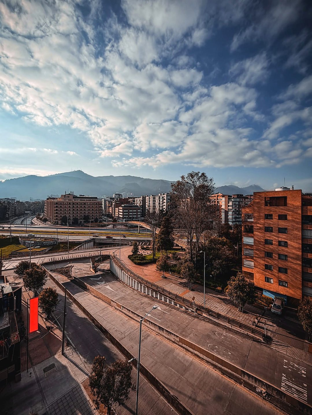 Vista de Bogotá com prédios de tijolinho e as montanhas dos Andes ao fundo