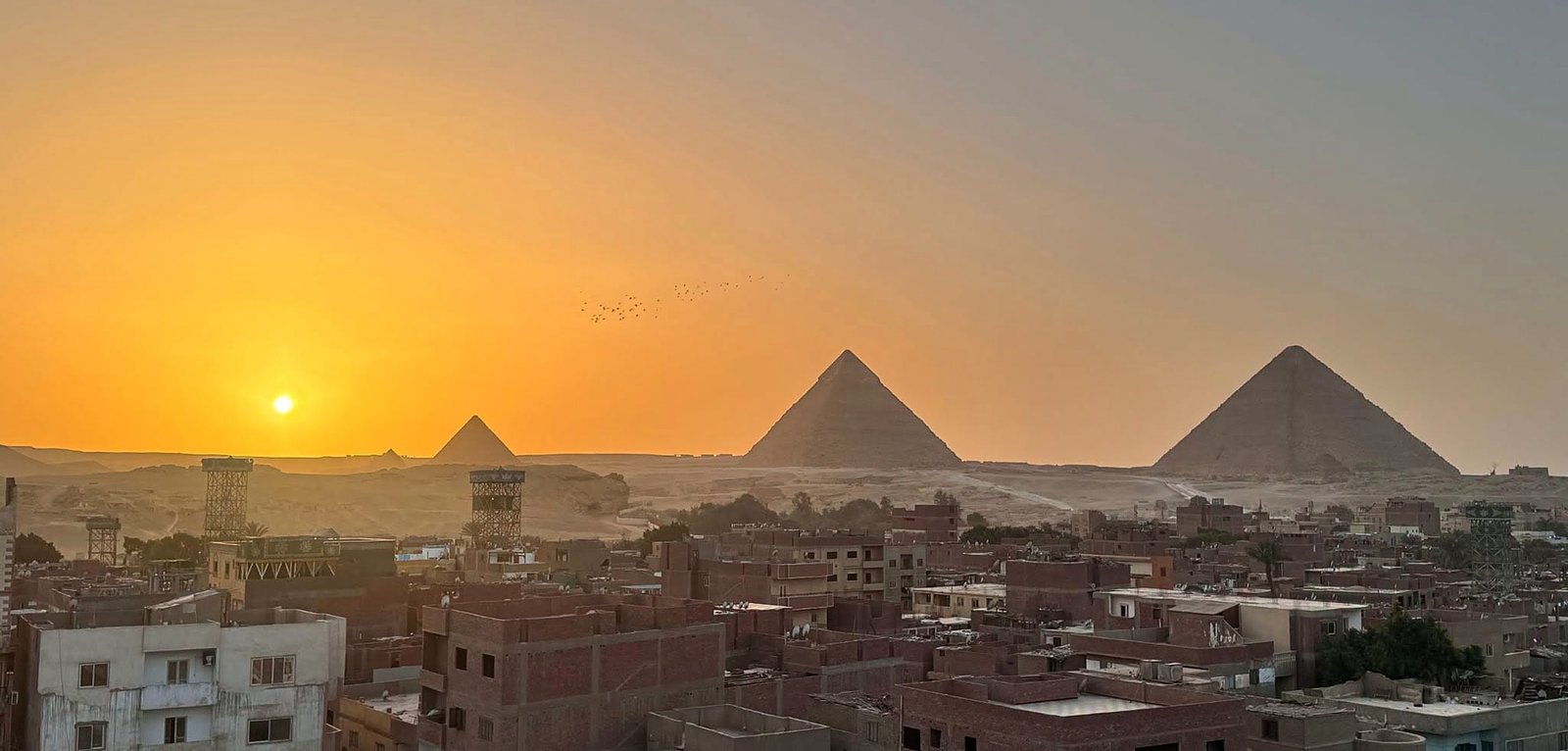 Pirâmides de Gizé ao pôr do sol vistas do Cairo, Egito