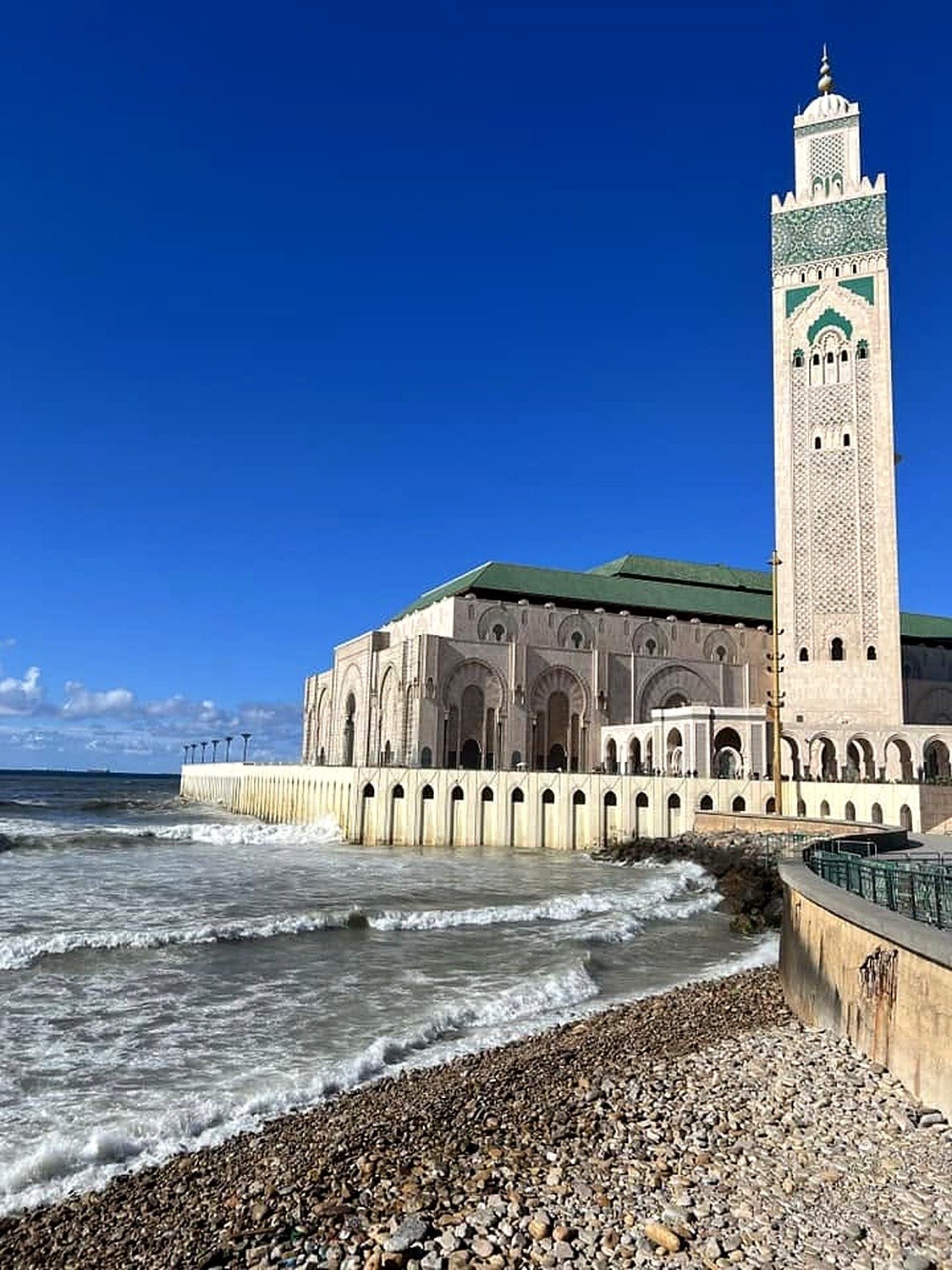 Mesquita Hassan II vista da praia de pedras com as ondas do Atlântico