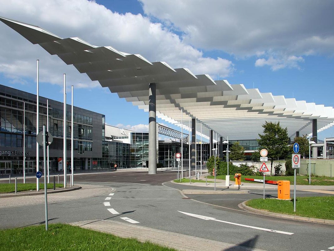 Cobertura metálica em forma de asas na área de acesso do centro de feiras NürnbergMesse, em Nuremberg