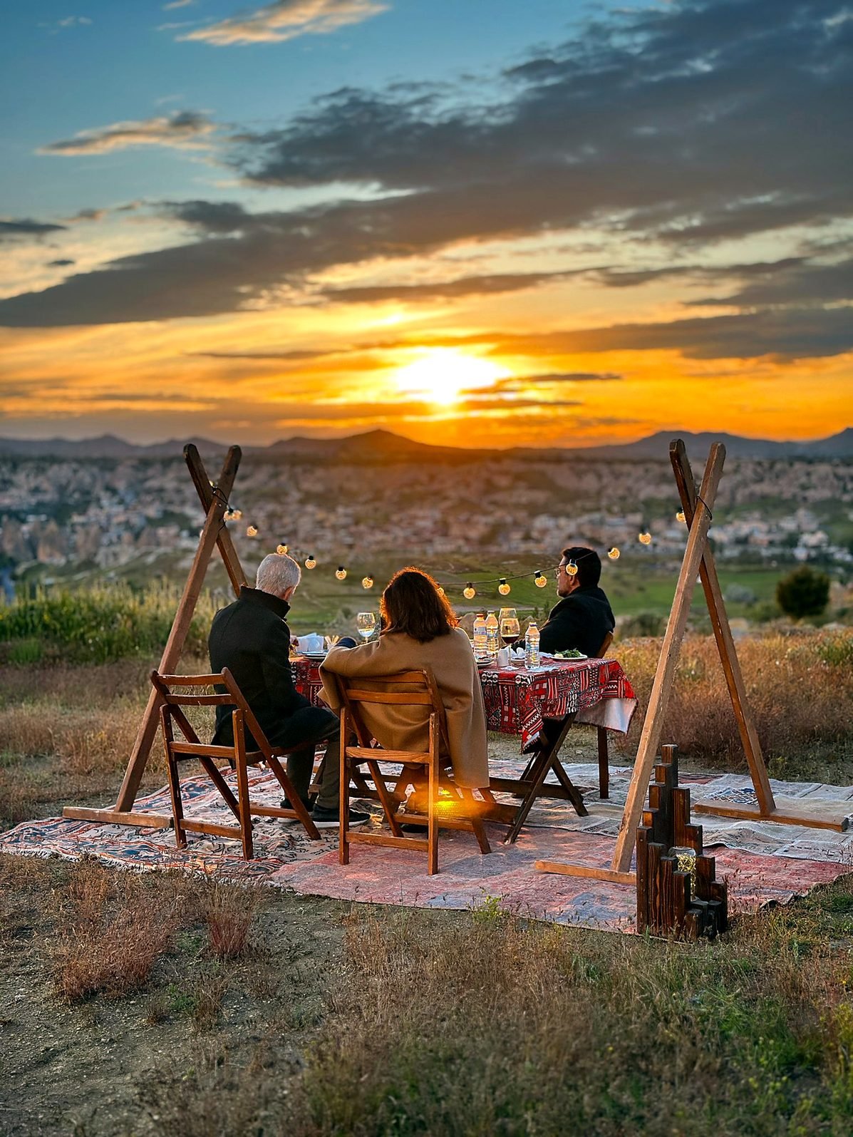 Clientes da Kleos em jantar privativo ao pôr do sol sobre os vales da Capadócia