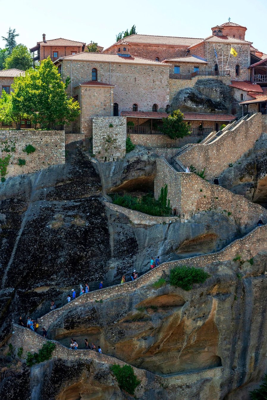 Turistas subindo a escadaria esculpida na rocha até o Mosteiro do Grande Meteoro, em Meteora