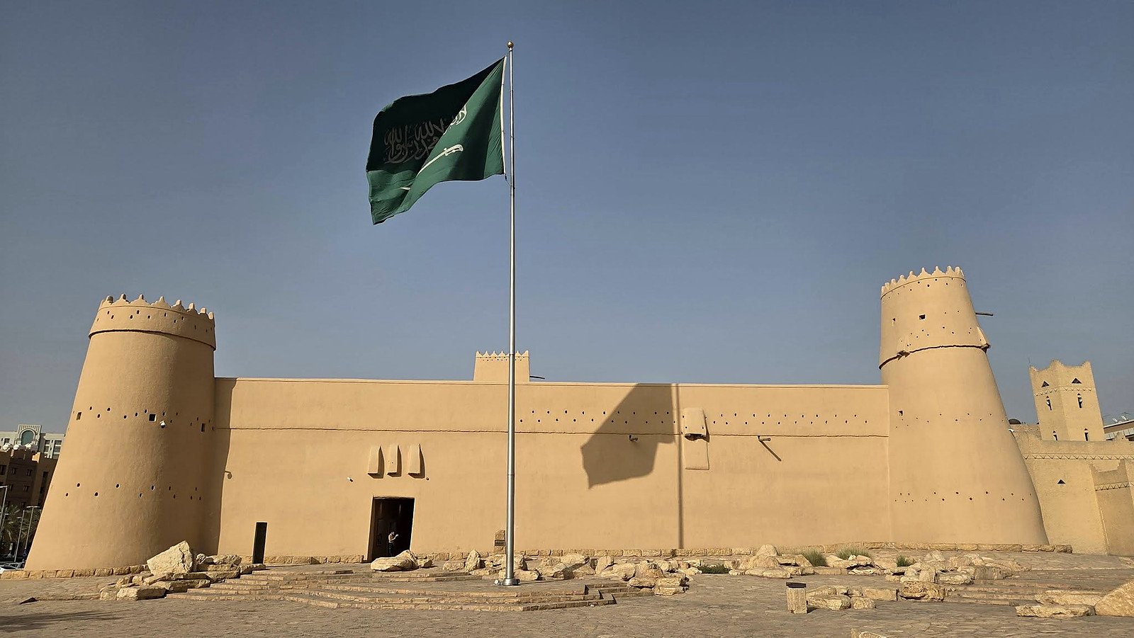 Forte Masmak em Riade, construção de adobe com torres e a bandeira da Arábia Saudita
