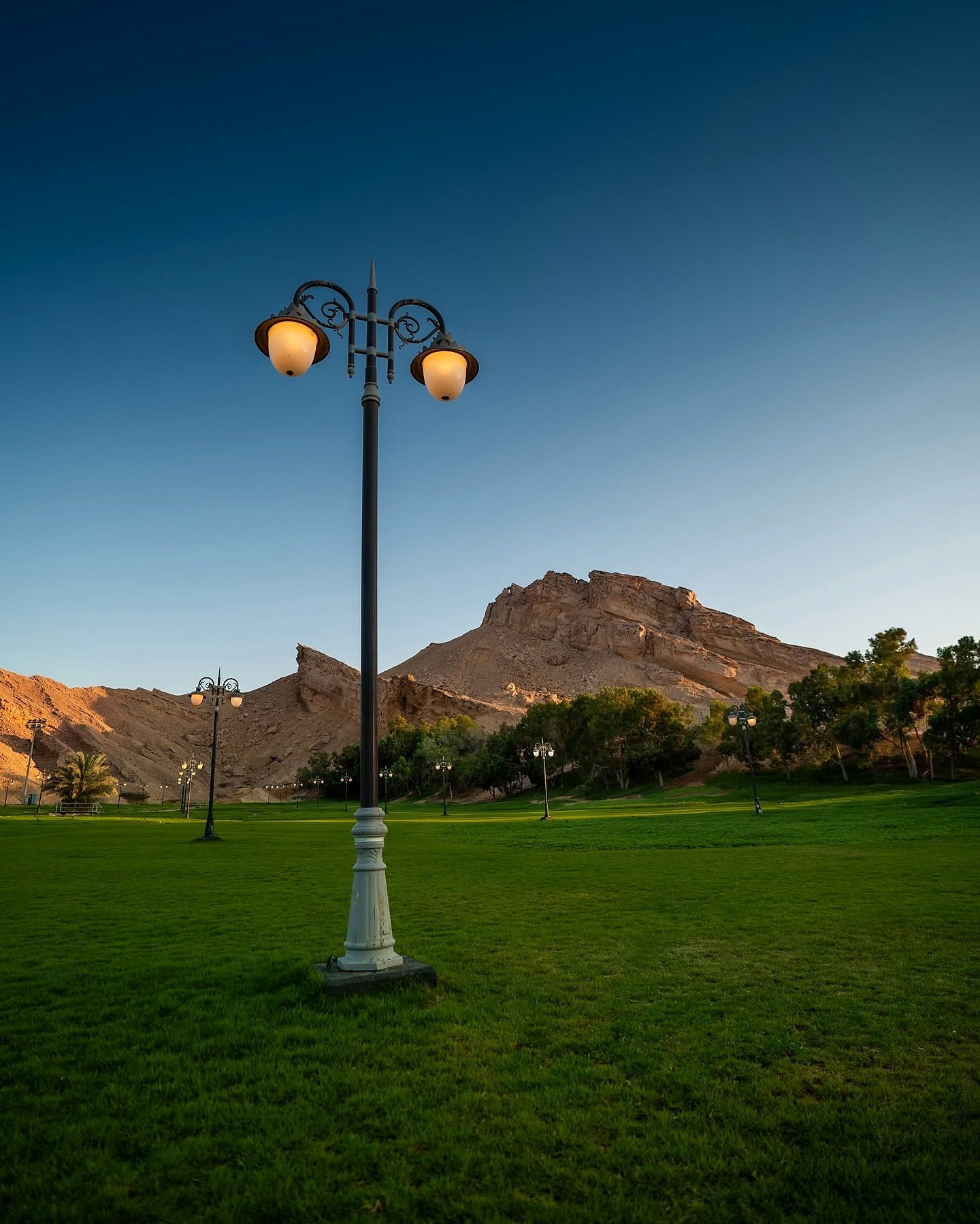 Gramados do oásis de Al Ain aos pés da montanha Jebel Hafeet