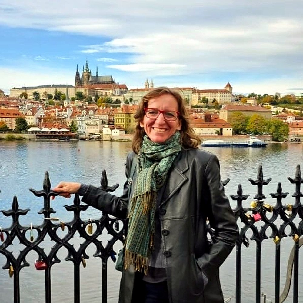 Guia Martina às margens do rio Vltava com o Castelo de Praga ao fundo
