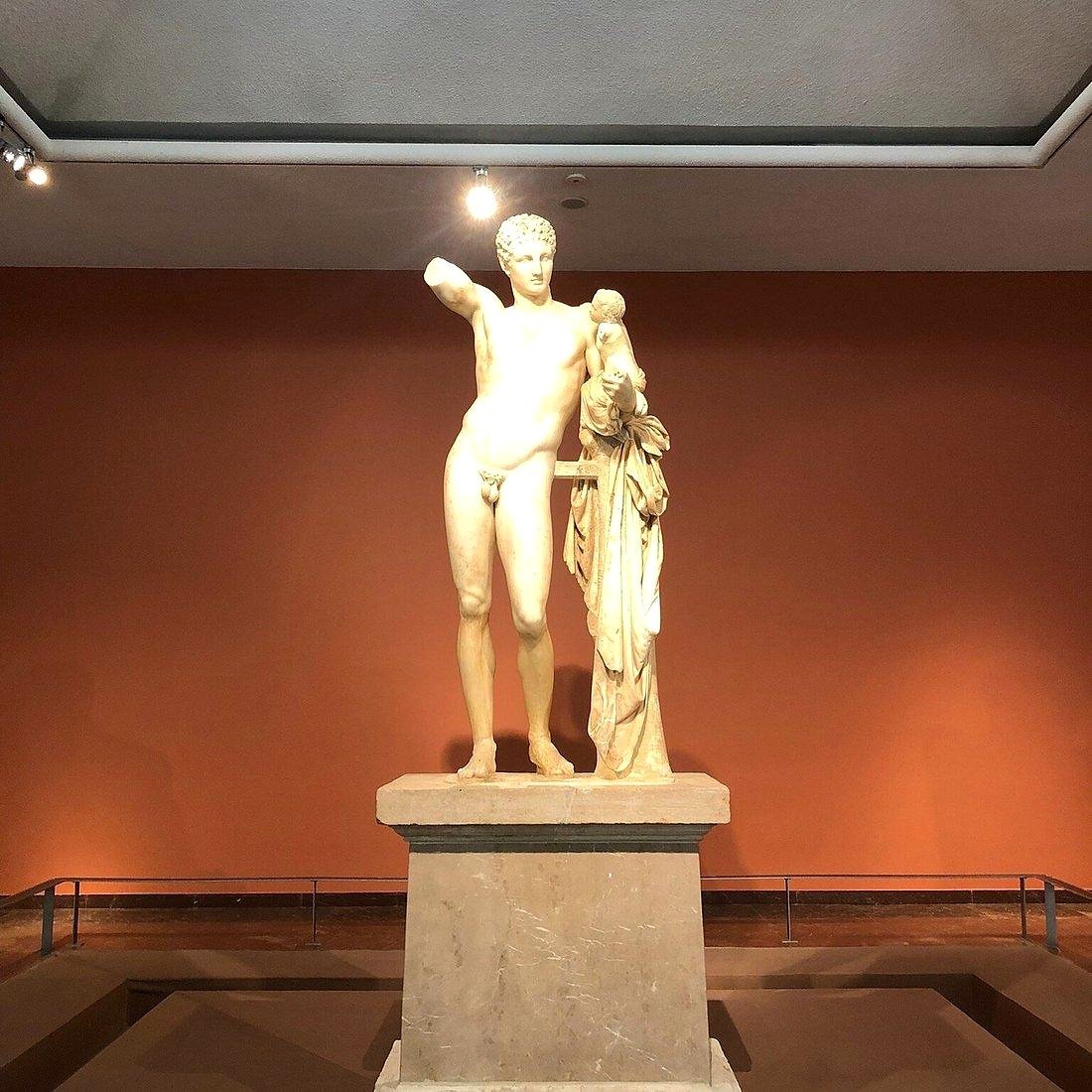 Est&aacute;tua de m&aacute;rmore de Hermes de Prax&iacute;teles segurando o pequeno Dion&iacute;sio, no Museu Arqueol&oacute;gico de Ol&iacute;mpia