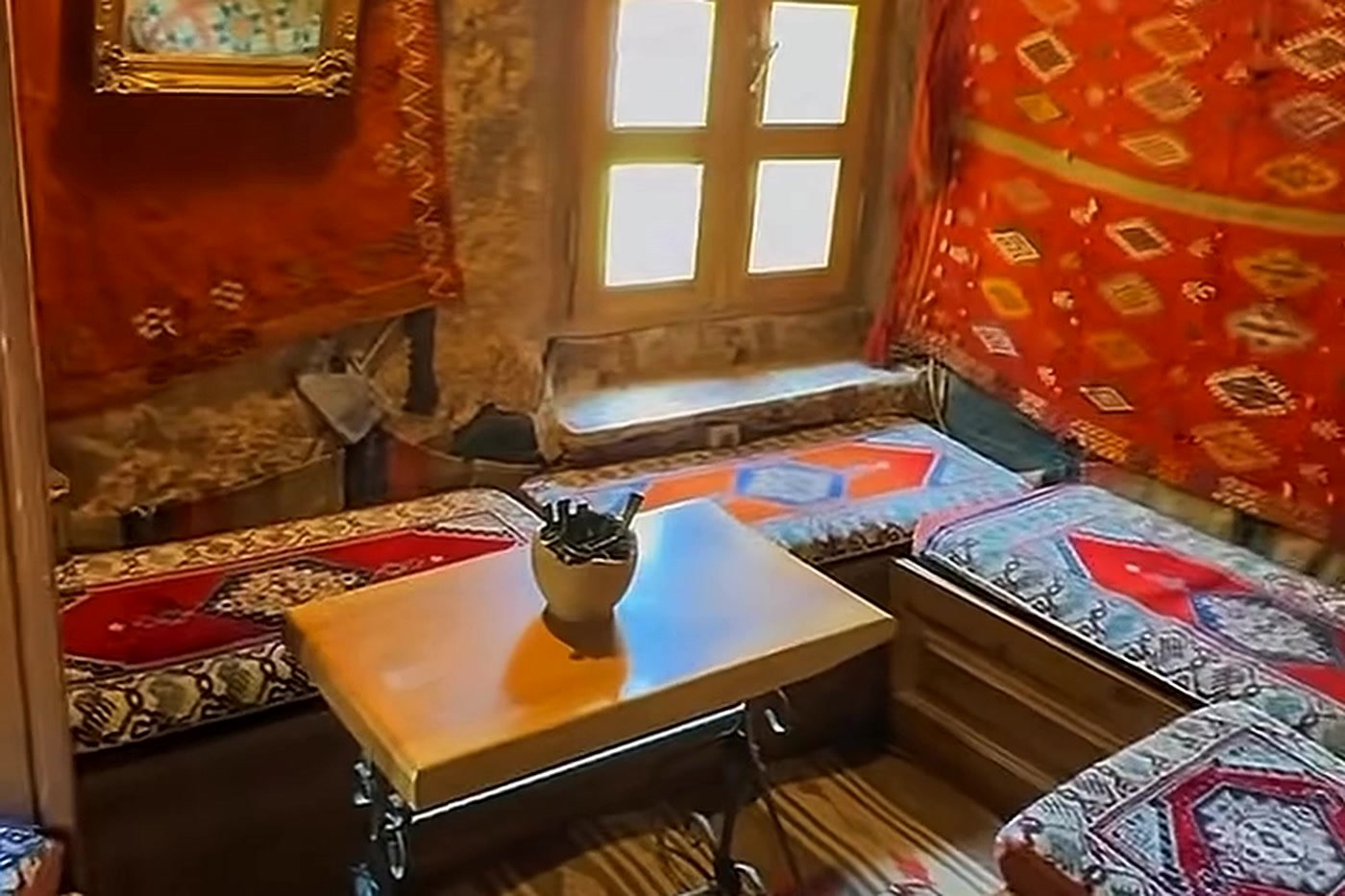 Quarto de hotel-caverna decorado com tapetes turcos na Capadócia