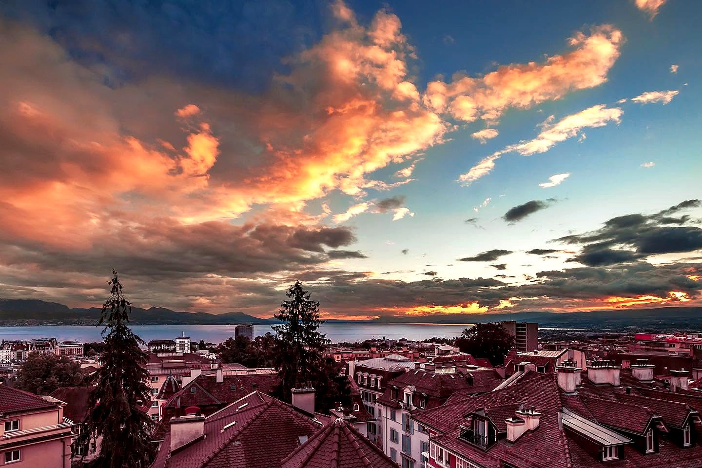 Pôr do sol sobre os telhados de Lausanne e o Lago Léman, na Suíça