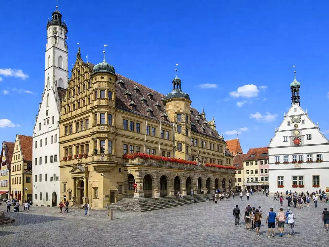 Praça Marktplatz de Rothenburg ob der Tauber com a prefeitura renascentista, a torre gótica e a Ratstrinkstube branca