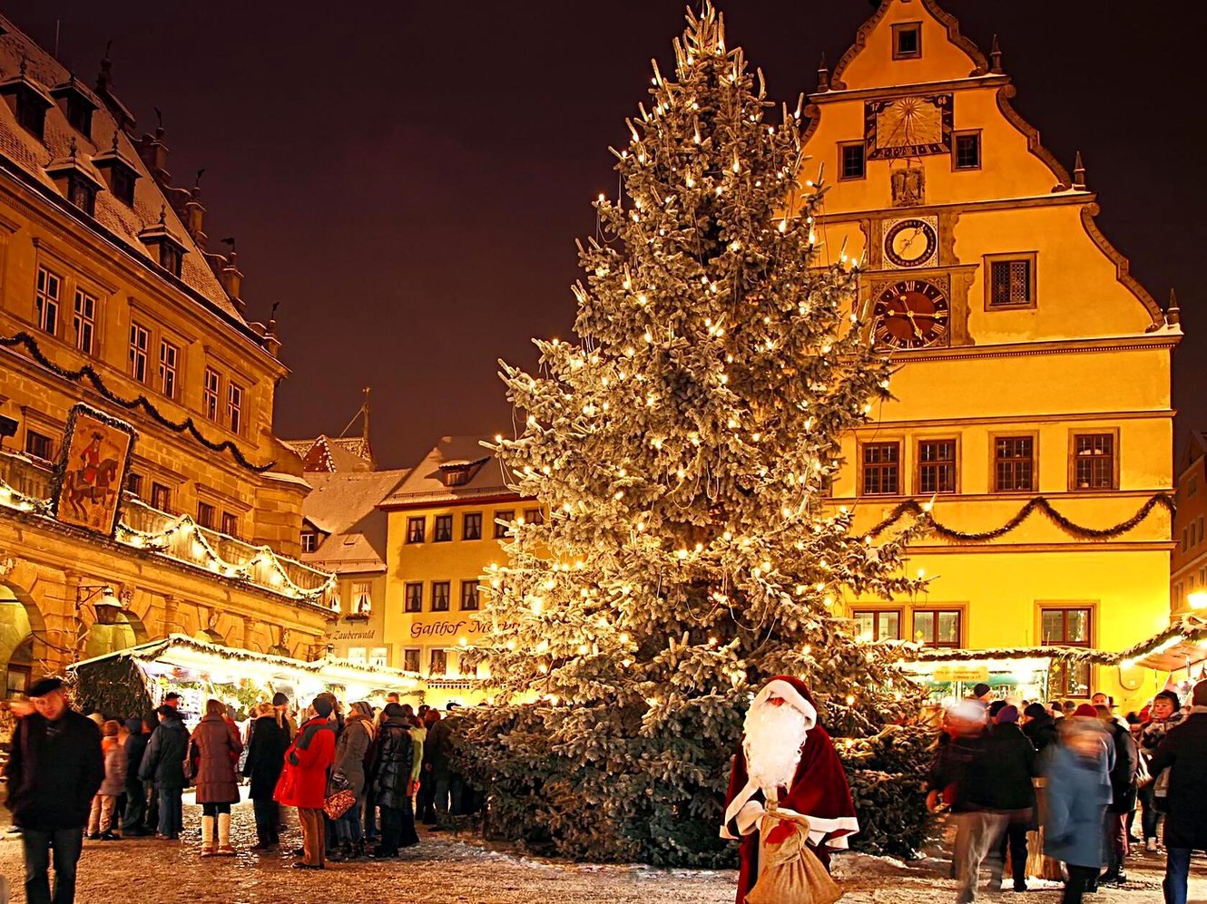 Grande árvore de Natal iluminada na Marktplatz de Rothenburg durante o Reiterlesmarkt, com a Ratstrinkstube ao fundo