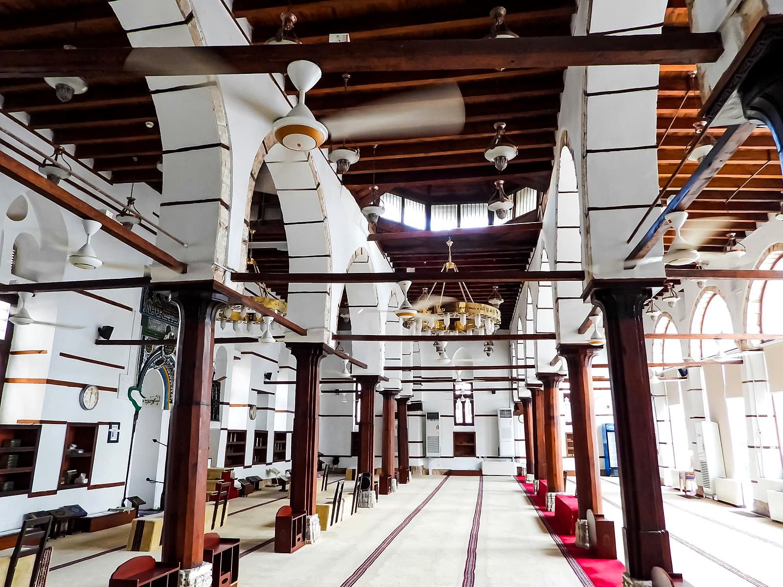 Interior de mesquita histórica em Al-Balad com colunas de madeira e arcos brancos