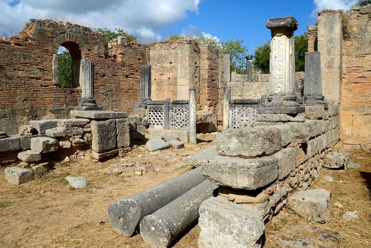 Interior da Oficina de F&iacute;dias em Ol&iacute;mpia com colunas e placas esculpidas da antiga bas&iacute;lica crist&atilde;