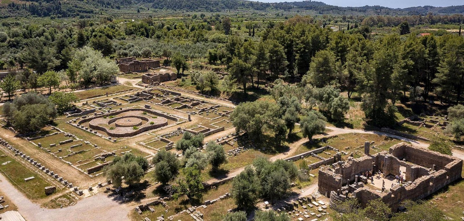 Vista a&eacute;rea do s&iacute;tio arqueol&oacute;gico de Ol&iacute;mpia com o p&aacute;tio circular do Leonidaion entre oliveiras