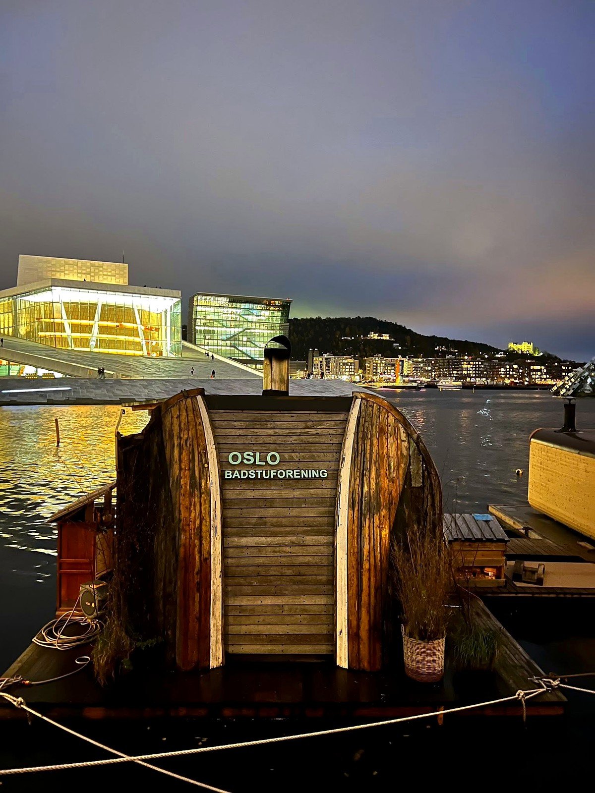Sauna flutuante em frente à Ópera de Oslo à noite