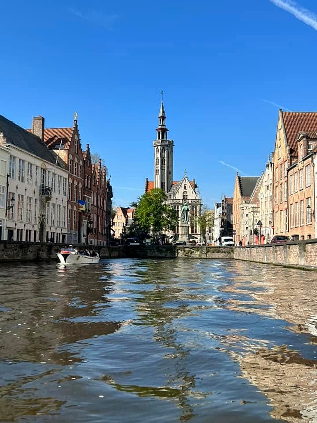 Canal Spiegelrei em Bruges com a praça Jan van Eyck e a torre da antiga Casa dos Mercadores ao fundo