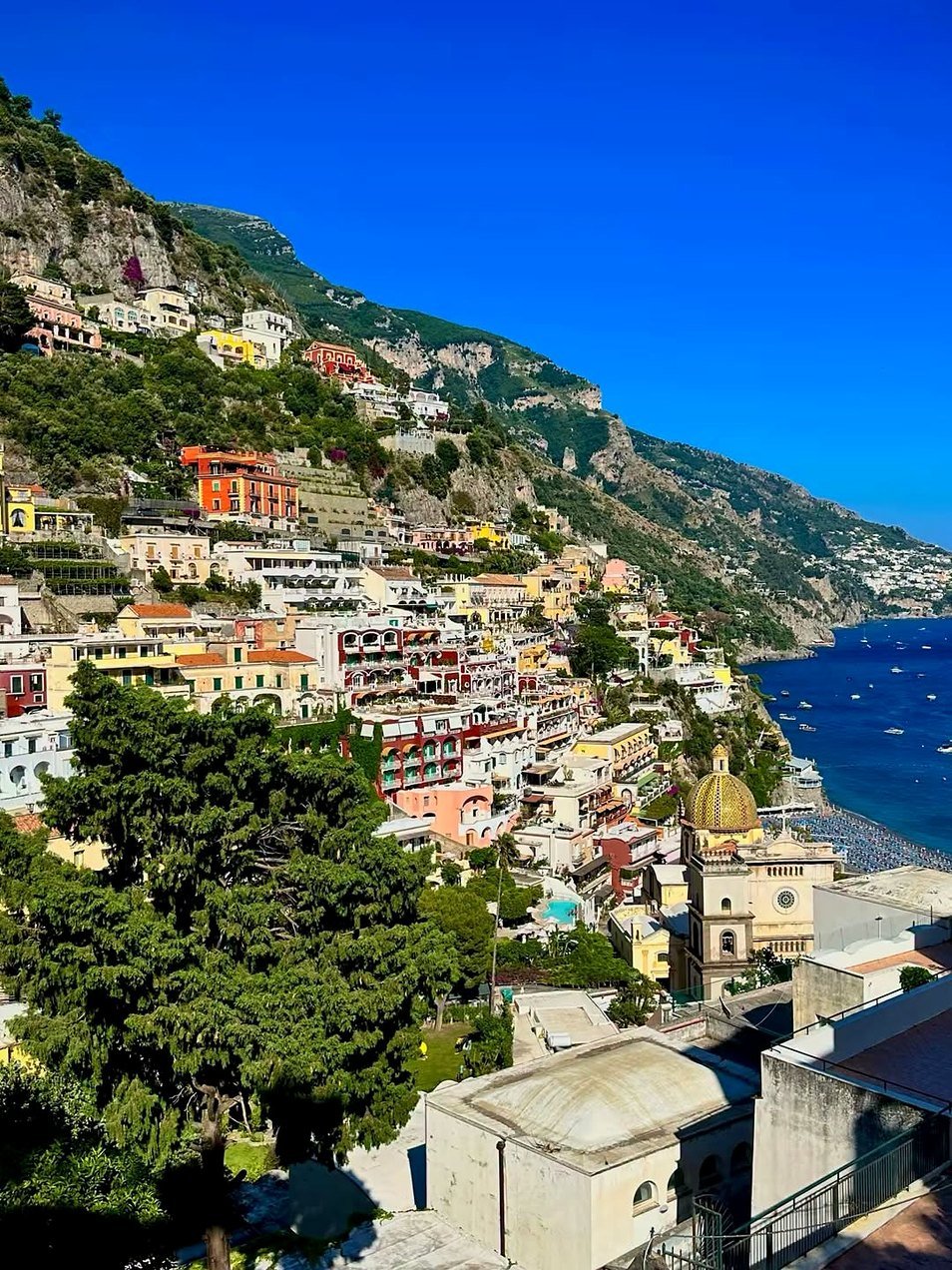 Positano com casas coloridas na encosta e a cúpula de Santa Maria Assunta