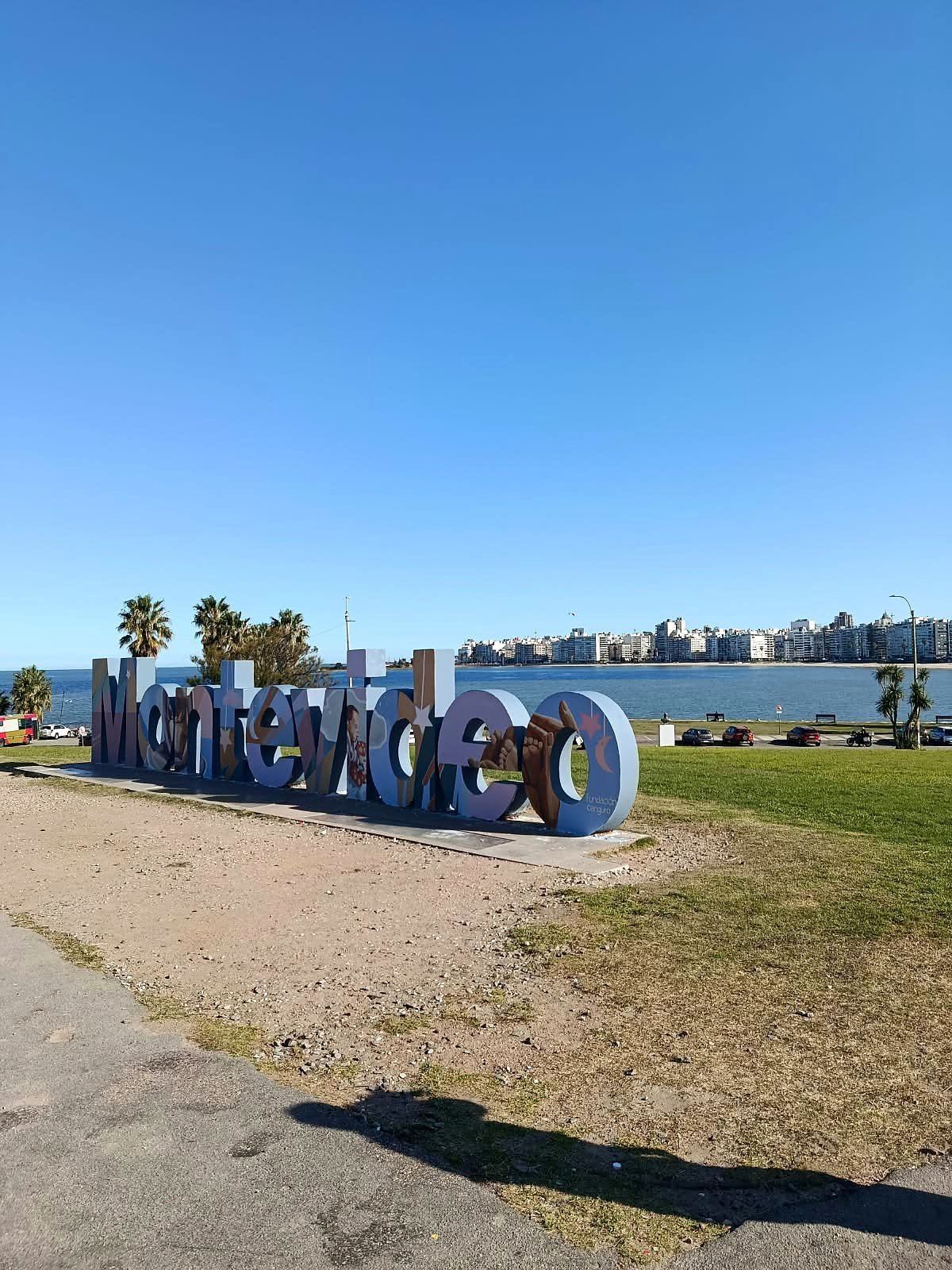 Letreiro colorido de Montevideo na Rambla, com a praia de Pocitos ao fundo