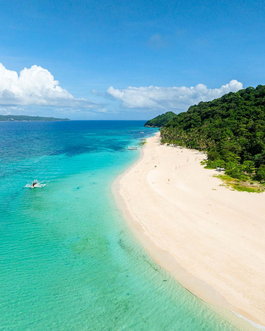 Puka Shell Beach em Boracay, com areia clara, mata verde e mar azul-turquesa