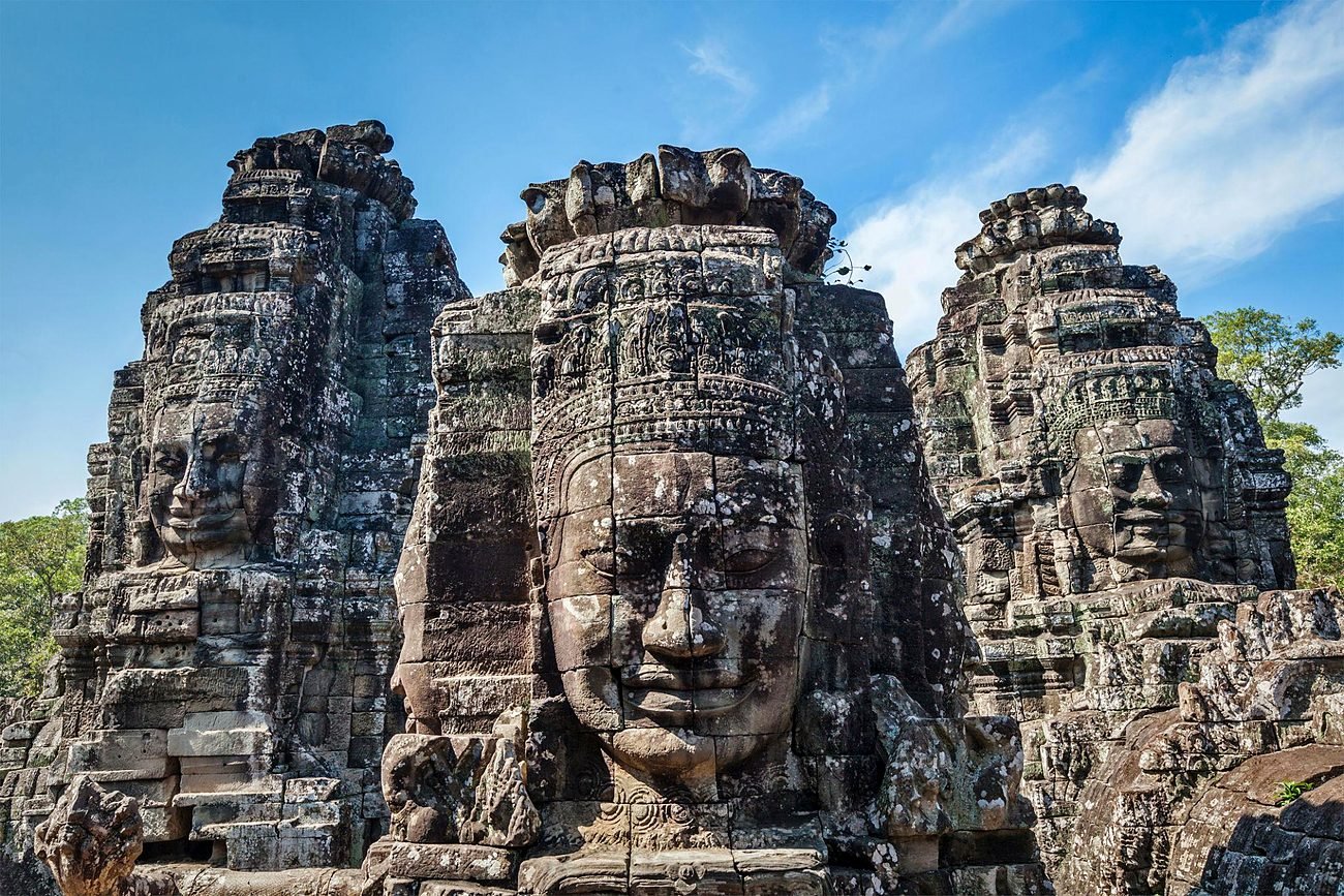 Três rostos de pedra nas torres do templo Bayon, em Siem Reap