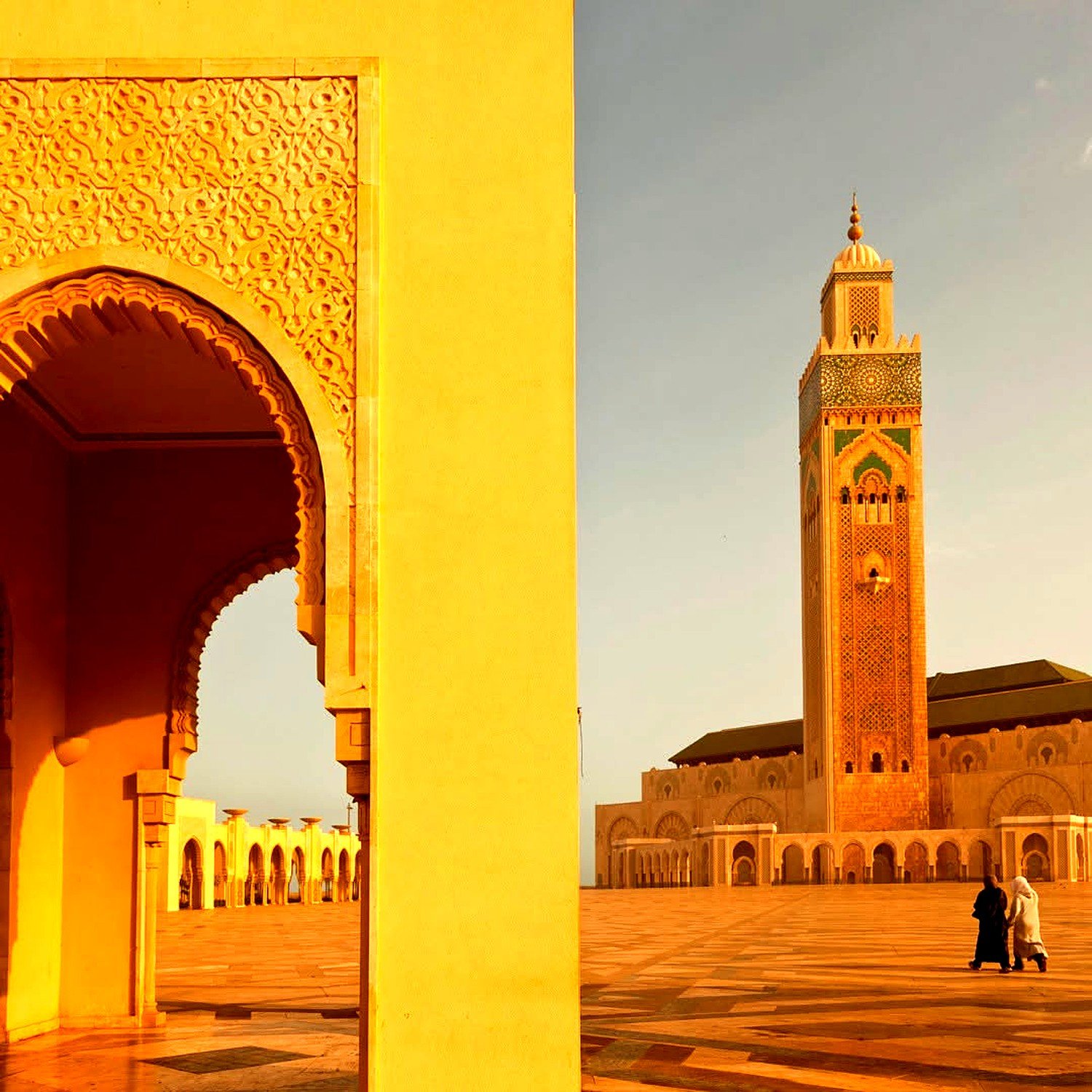 Minarete da Mesquita Hassan II e arco entalhado na luz dourada do fim de tarde