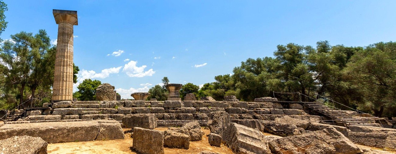 Plataforma do Templo de Zeus em Ol&iacute;mpia com a coluna reerguida e blocos de pedra