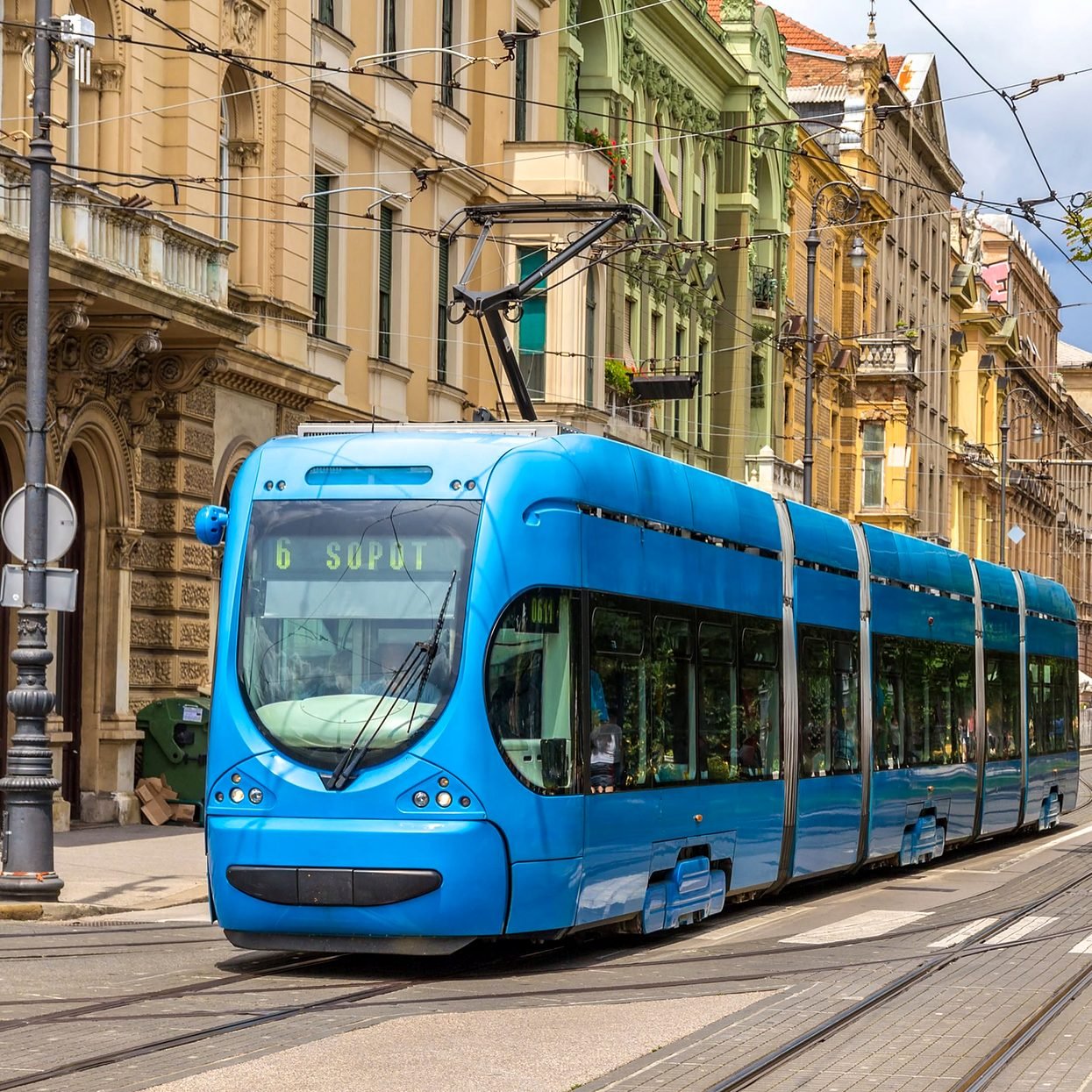 Bonde azul de Zagreb circulando entre prédios históricos da Cidade Baixa