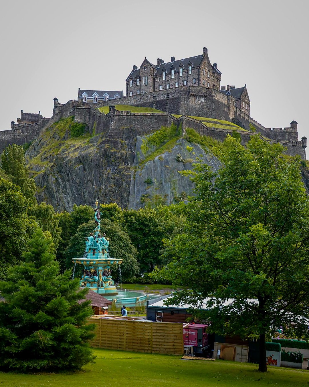 Castelo de Edimburgo sobre a rocha vulcânica, com a Ross Fountain nos jardins