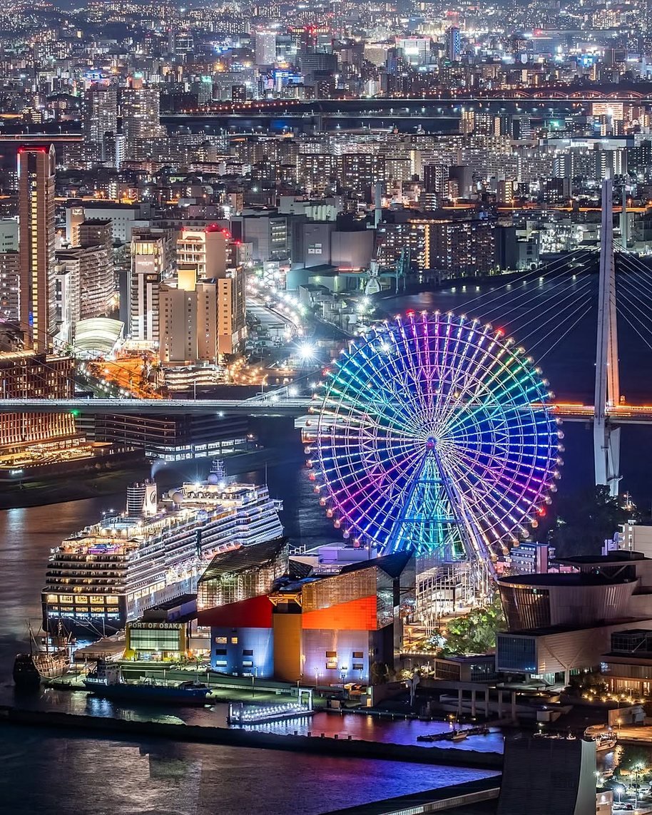 Roda-gigante de Tempozan iluminada, aquário Kaiyukan e navio no porto de Osaka à noite