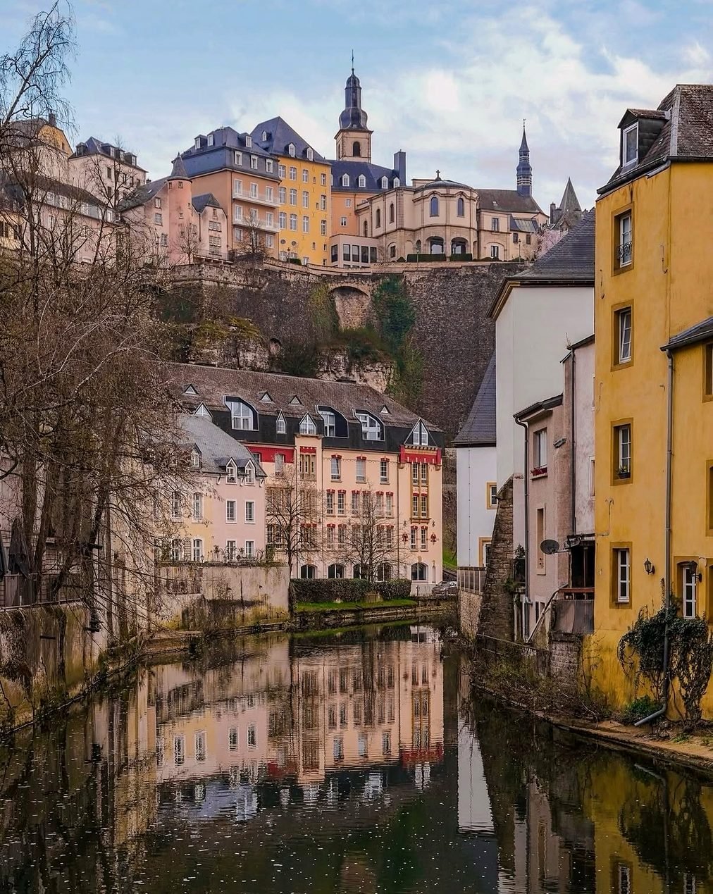 Casas coloridas refletidas no rio Alzette, no bairro do Grund, em Luxemburgo