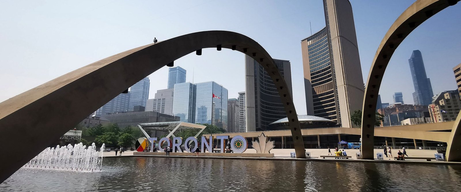 Guia brasileiro em Toronto: Nathan Phillips Square com o letreiro TORONTO e a Prefeitura (City Hall), no Canadá