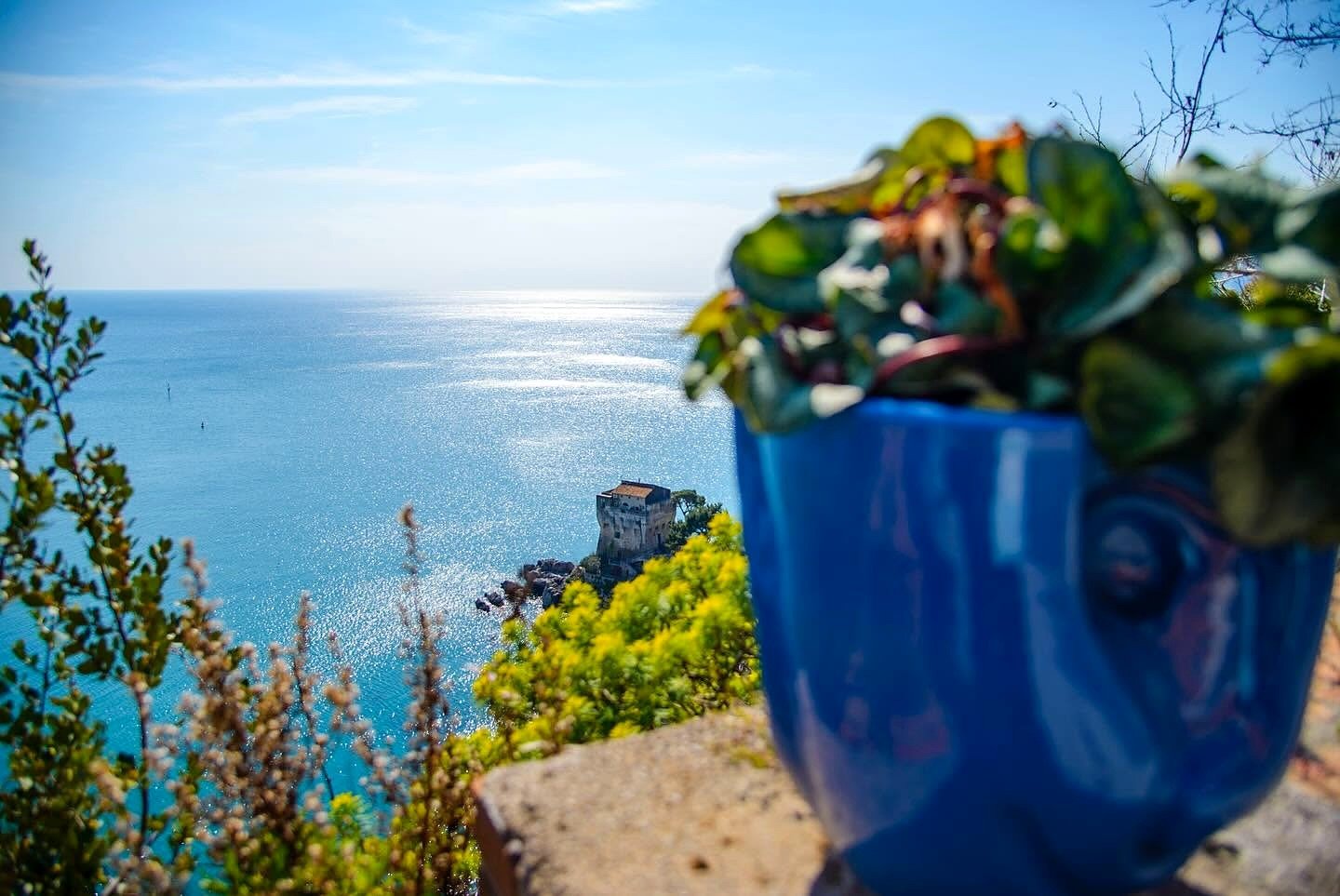 Vaso de cerâmica azul de Vietri sul Mare com vista para o mar e uma torre antiga