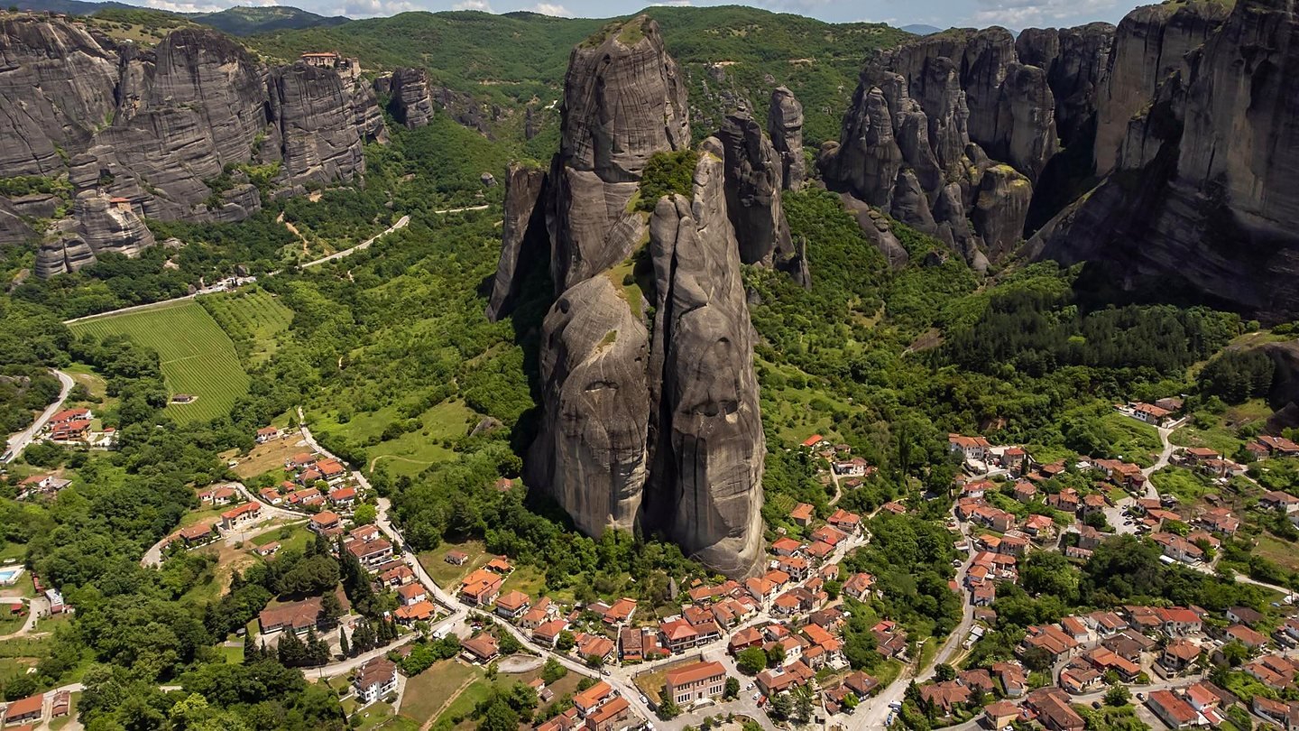 Vista aérea de Kastraki e do grande pilar de rocha de Meteora, com mosteiros nas encostas ao fundo
