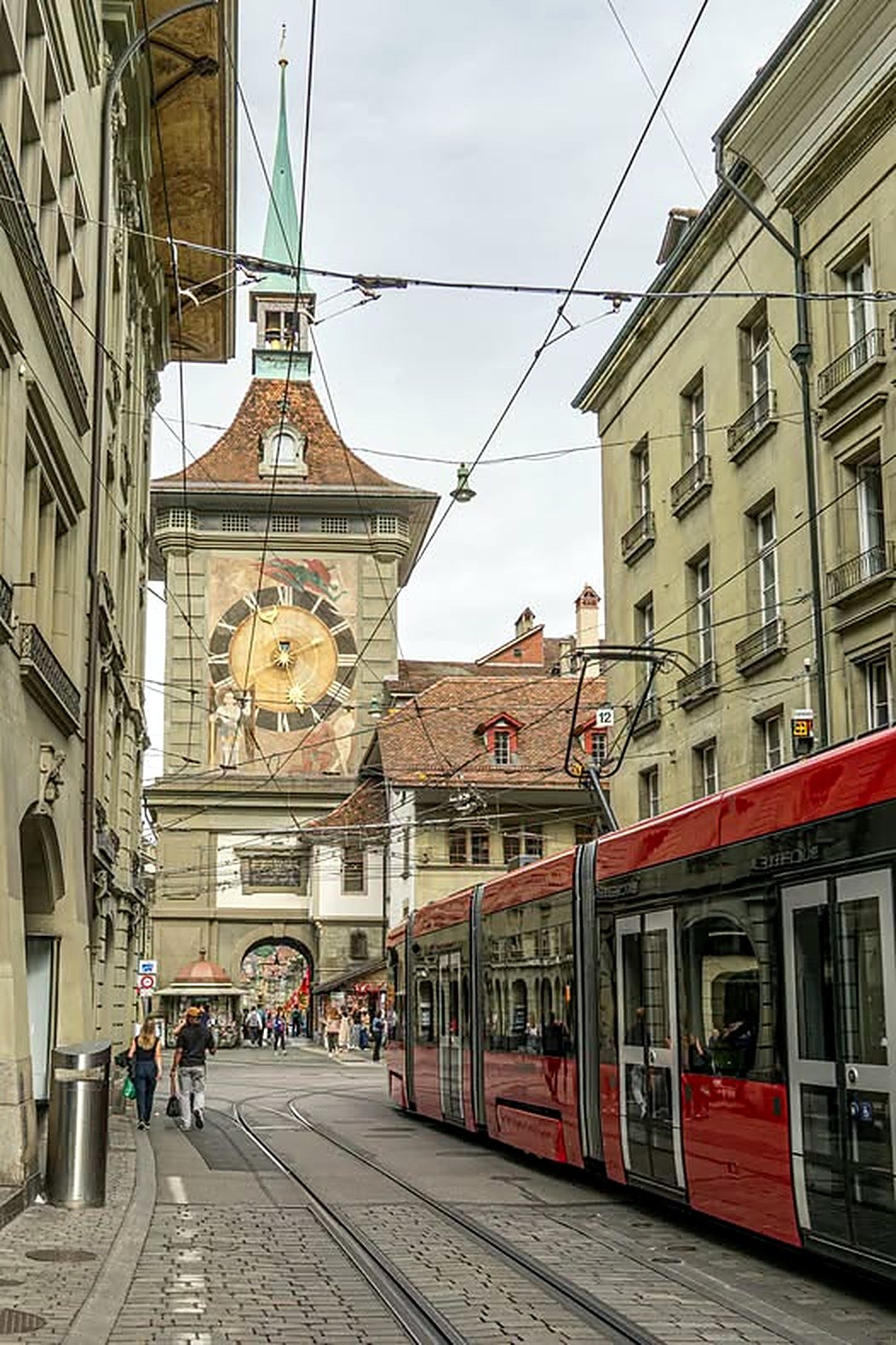 Bonde vermelho passando ao lado da Torre do Relógio Zytglogge em Berna