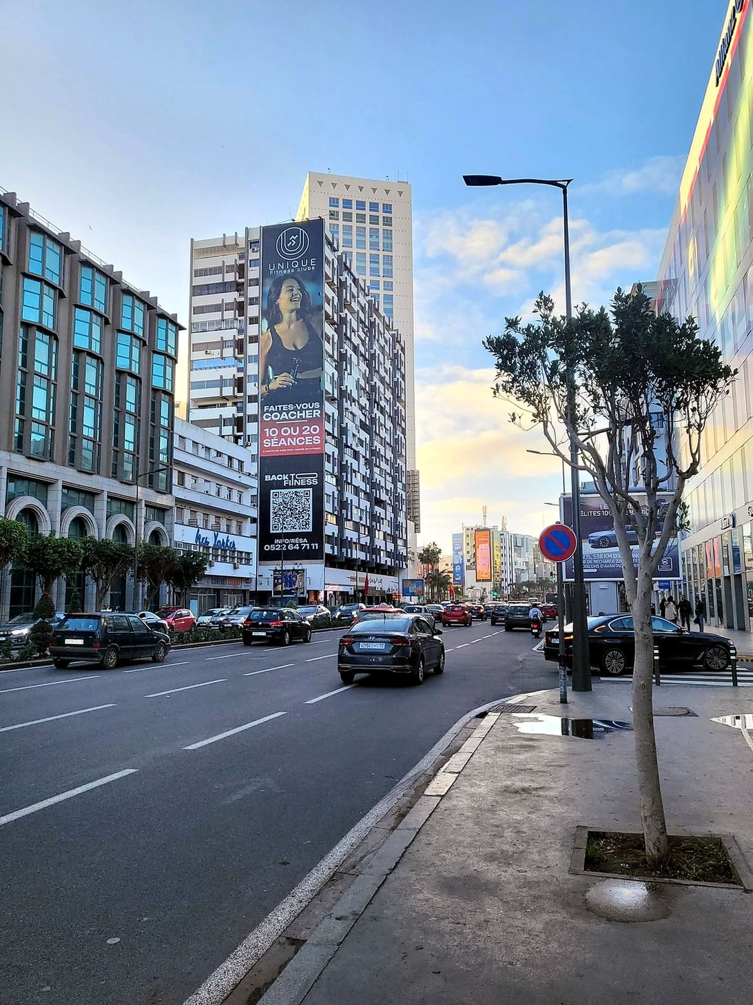 Avenida movimentada no centro moderno de Casablanca com prédios altos e trânsito